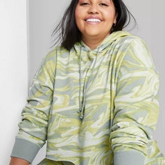 A model wearing the same cropped hoodie in green swirl