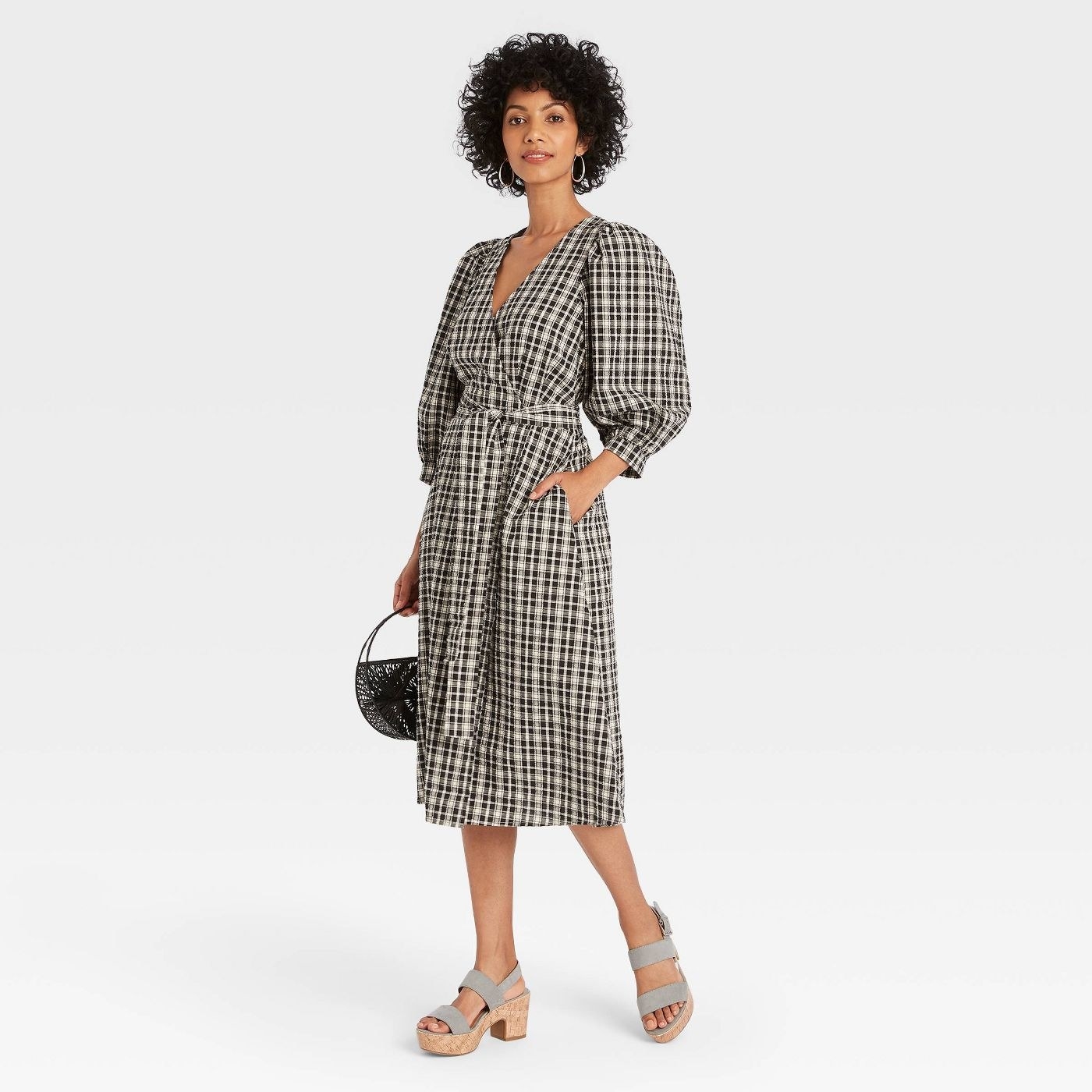 model in the plaid v-neck wrap midi dress with puffy three quarter sleeves