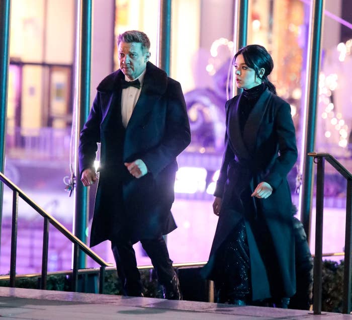 Jeremy in a tux and coat walking next to Haille, also in a coat, as they walk in a scene from the series