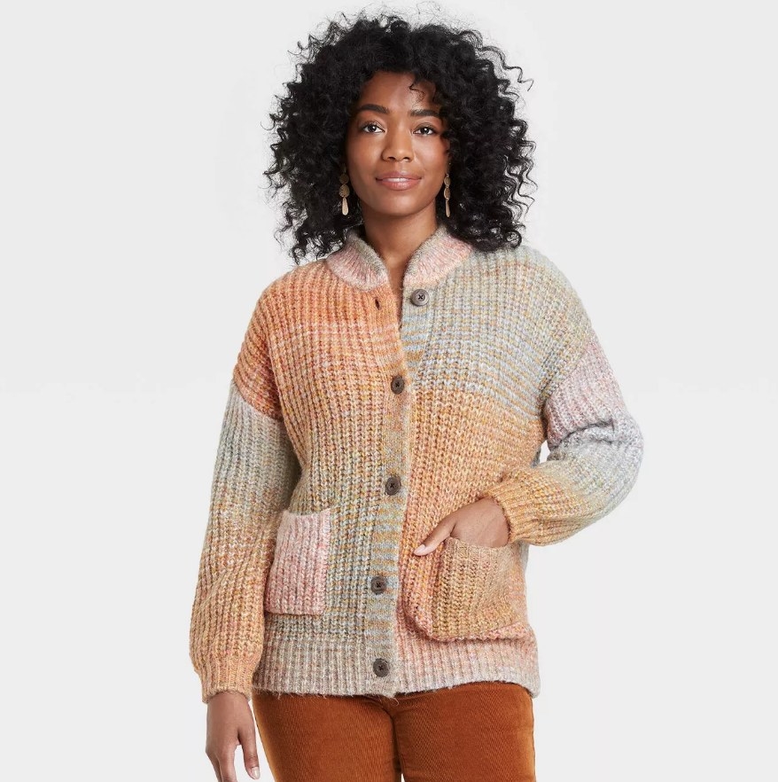 A model wearing a multicolored, oversized button-front grandpa cardigan