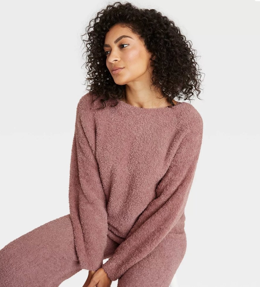 A model wearing a fuzzy mauve pullover sweater
