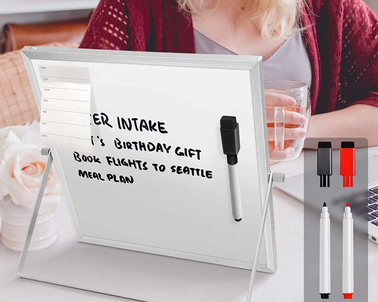 A mini white board on a desk with a person sitting behind it