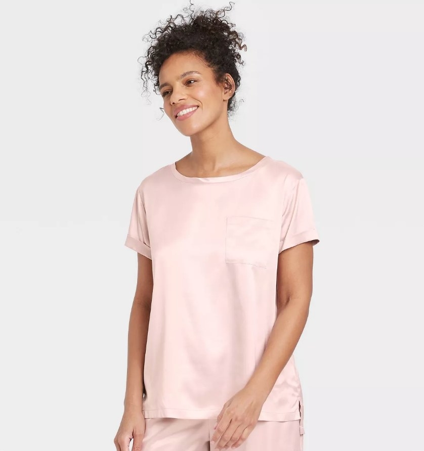 A model wearing a pink satin t shirt with a front pocket