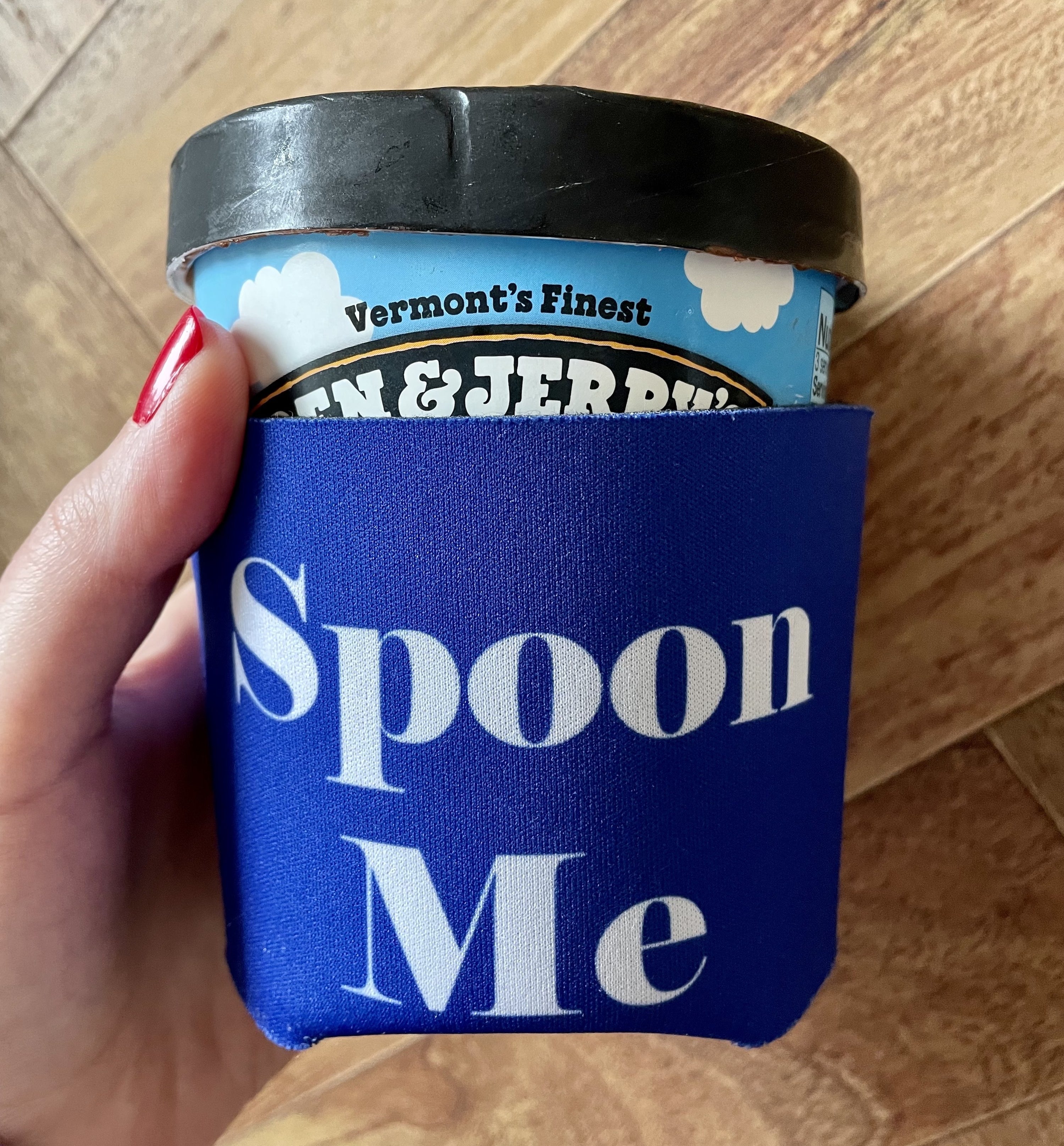 blue cozy that says "spoon me" around a pint of ben & jerry's