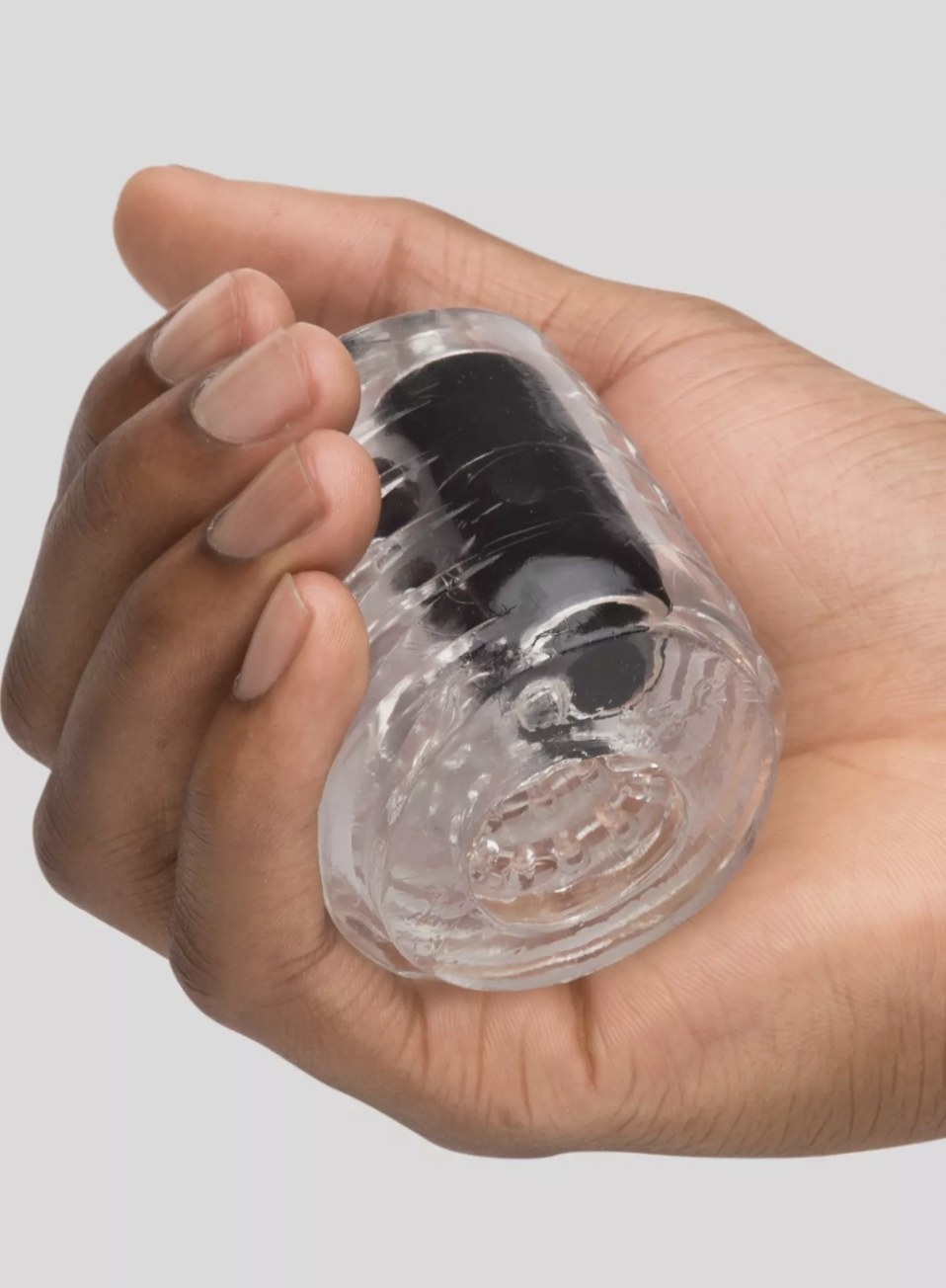 The clear vibrating stroker held in someone&#x27;s palm