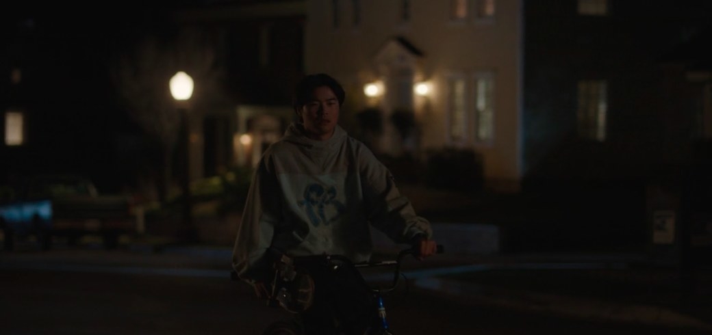 Shuji rides his bike down a dark street