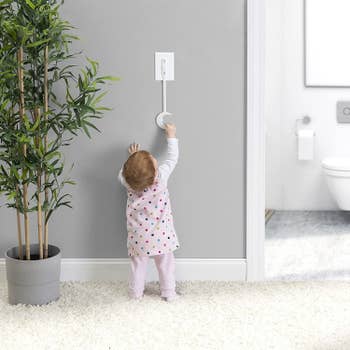 A child reaching for the light switch extender