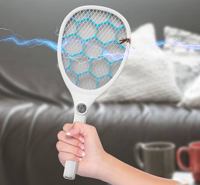 model holding the racket-shaped fly swatter