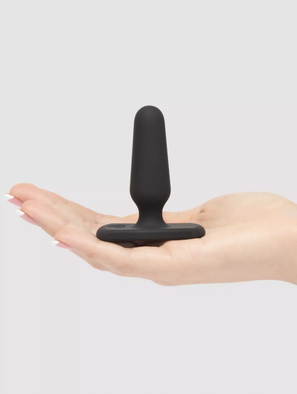 The black butt plug held in someone&#x27;s palm