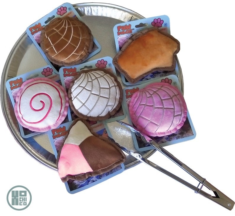 Six multicolored Pan Dulce-inspired chew toys inside a silver pan