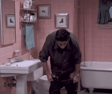gif of Ross from friends trying and failing to pull on tight leather pants