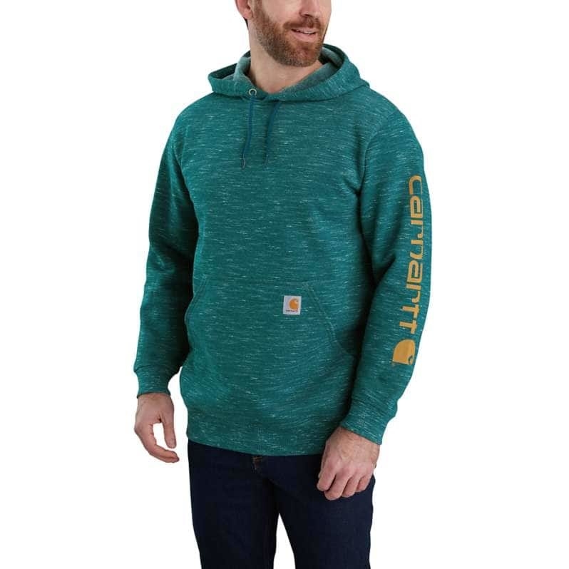 model wearing green-blue speckled hoodie that says carhartt in orange on the side of the arm