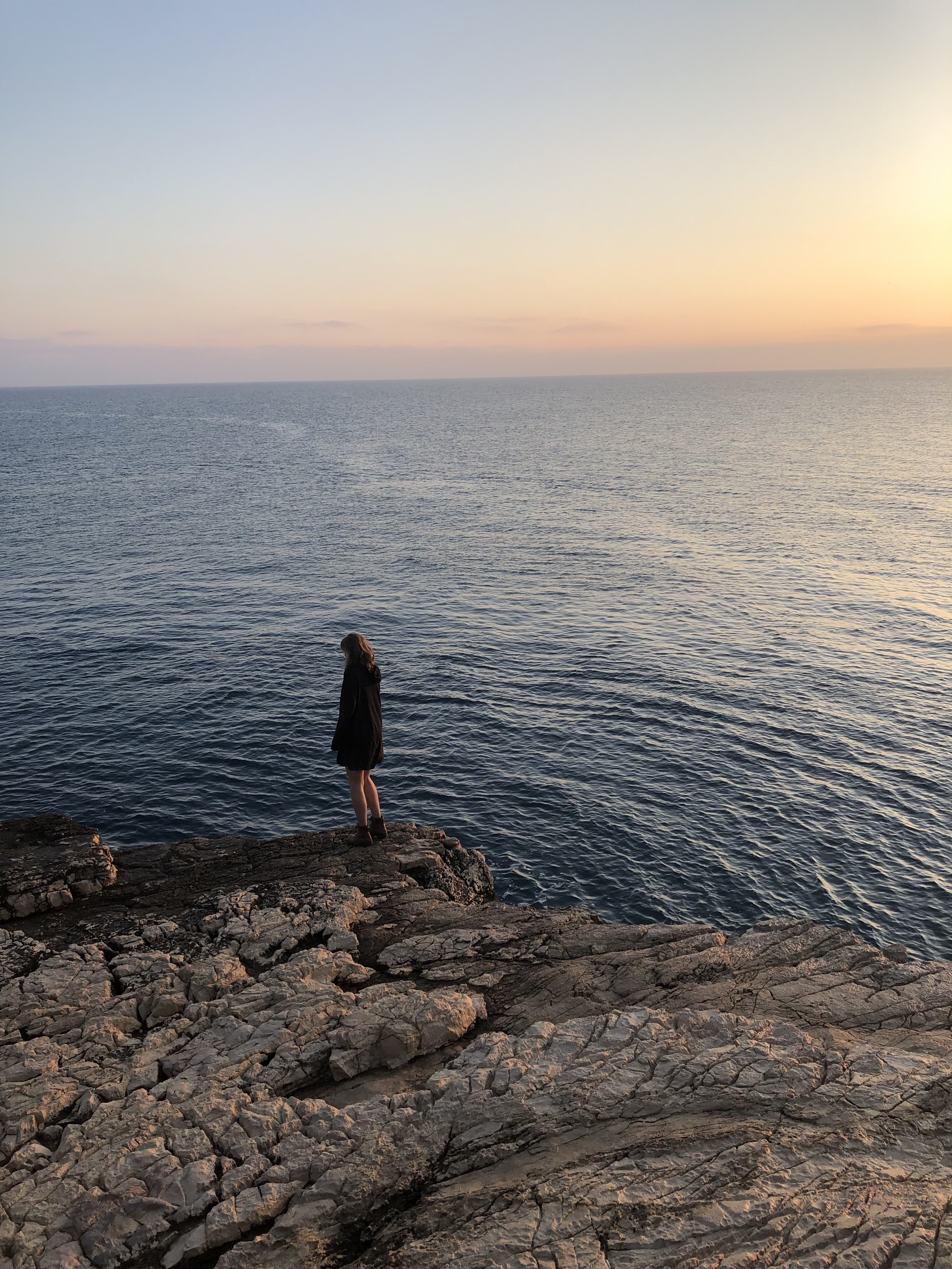 girl walking on rocks by the sea