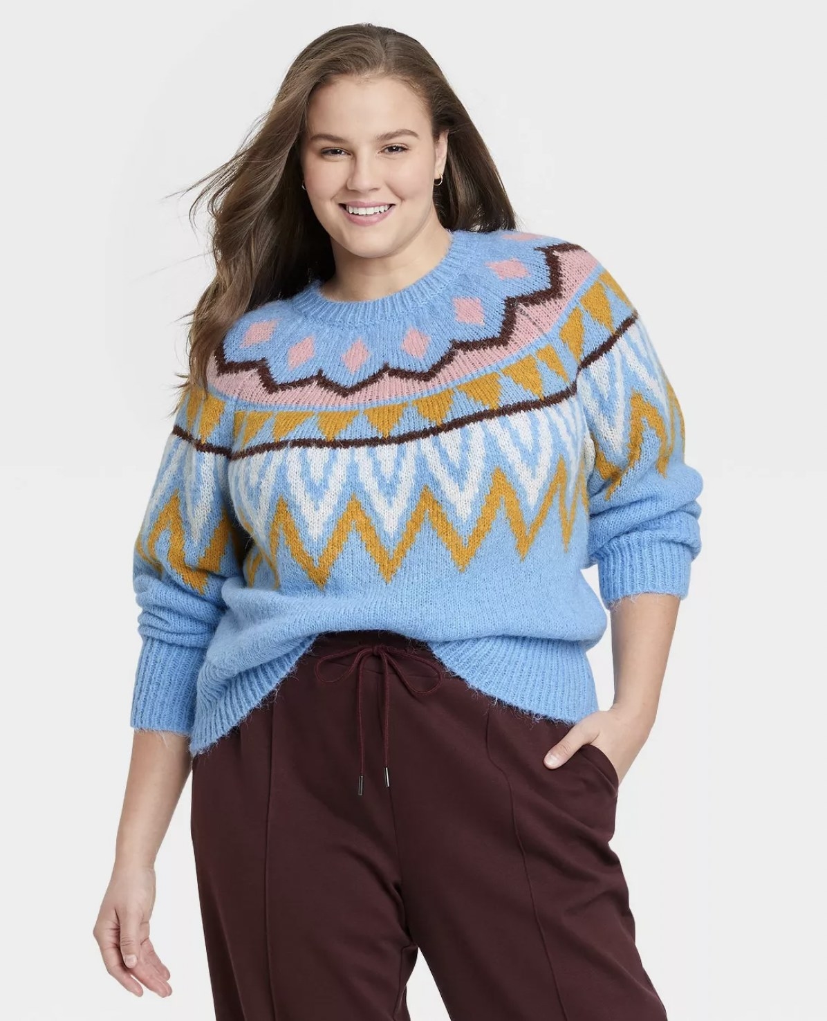 model in the blue, mustard, white, eggplant, and pink-colored sweater