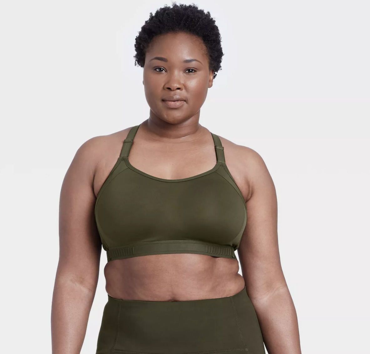 Model is wearing a forest green sports bra and matching leggings