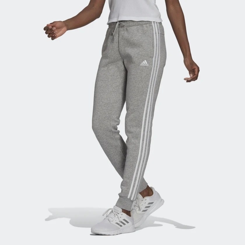 Model wearing grey pants, white sneakers and white top