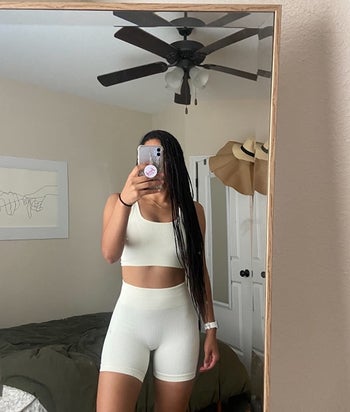 Reviewer wearing a white ribbed workout set of shorts and a tank top