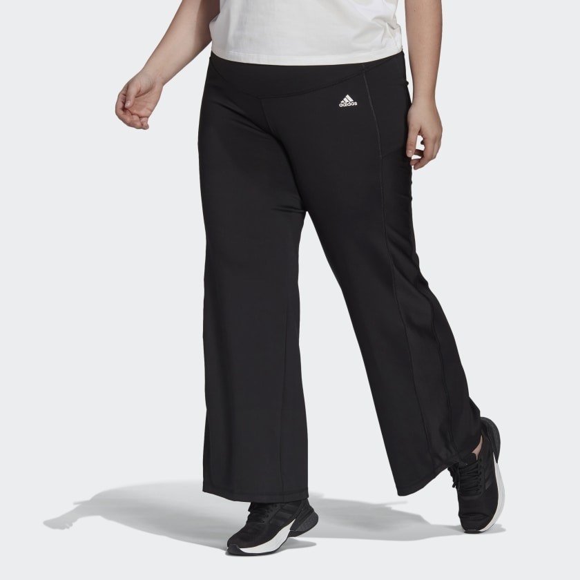 Model with black bootcut pants with black sneakers and white top