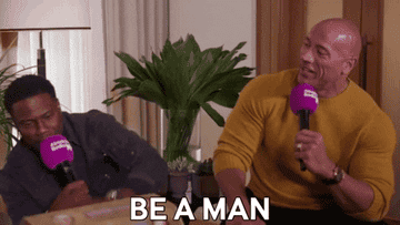 Dwayne Johnson says, &quot;Be a man,&quot; to Kevin Hart as they both hold microphones to their face during an Absolute Radio interview