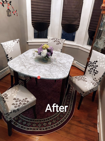 the same dining setup with light gray floral pattern slipcovers on the chair giving the impression that the chairs are upholstered in that fabric