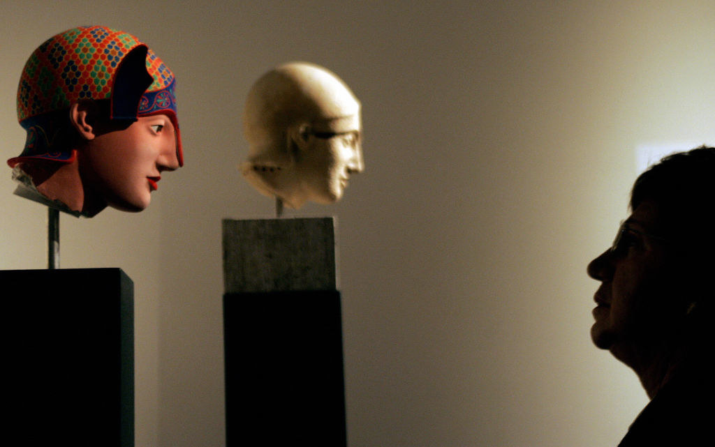 a visitor looks at the painted head of an archer
