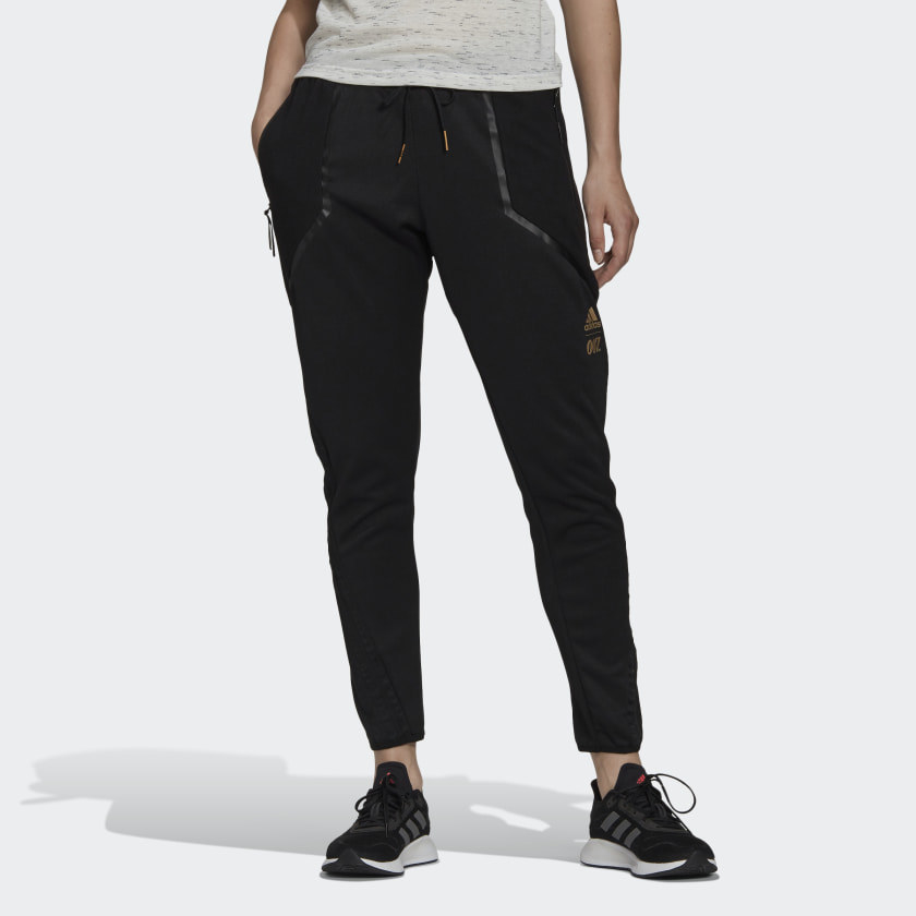 Model wearing black joggers with leather detail, black sneakers and grey top