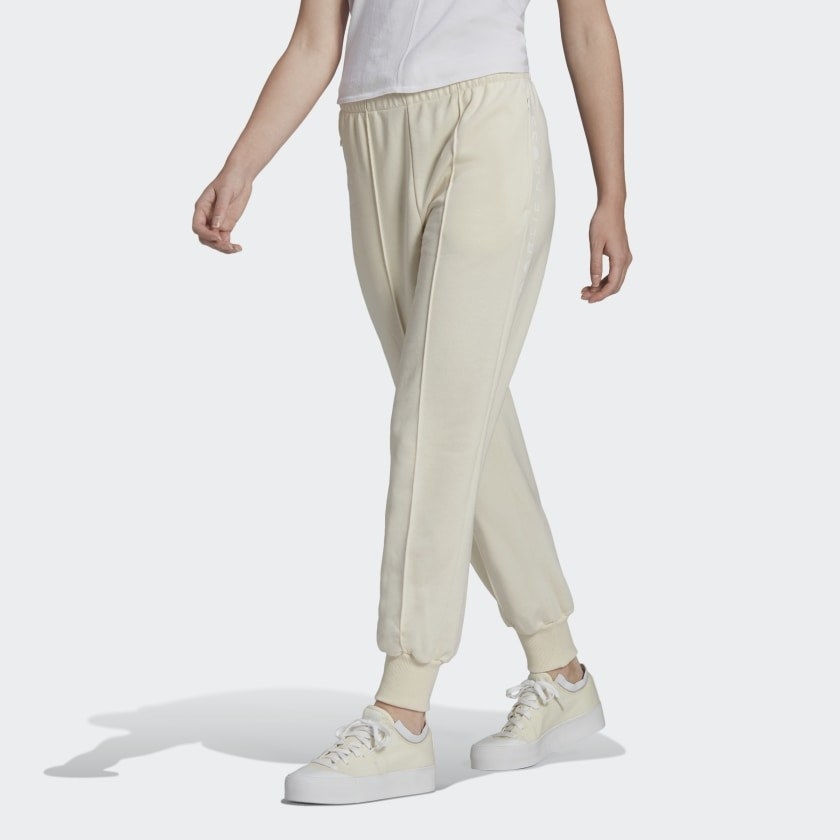 Model wearing cream joggers and cream sneakers