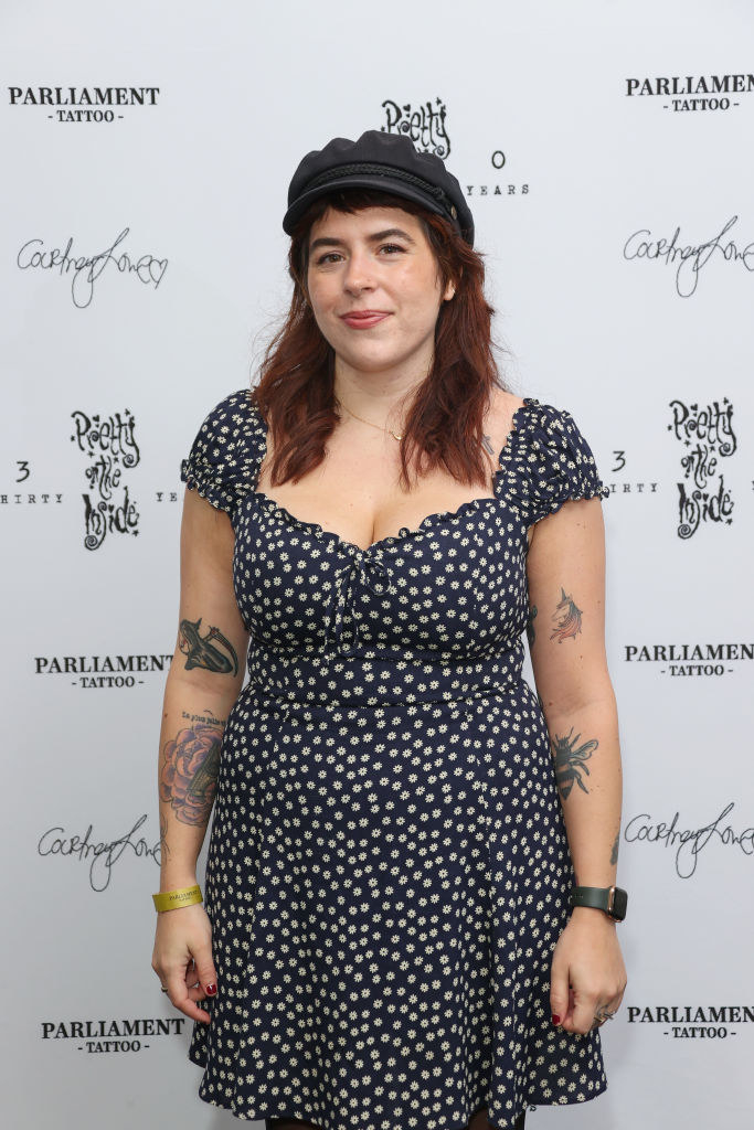 Bella in a polka-dot dress and newsboy cap and she's at a tattoo exhibit
