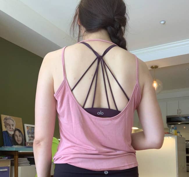 Reviewer is wearing a pink backless tank top with a purple bra underneath
