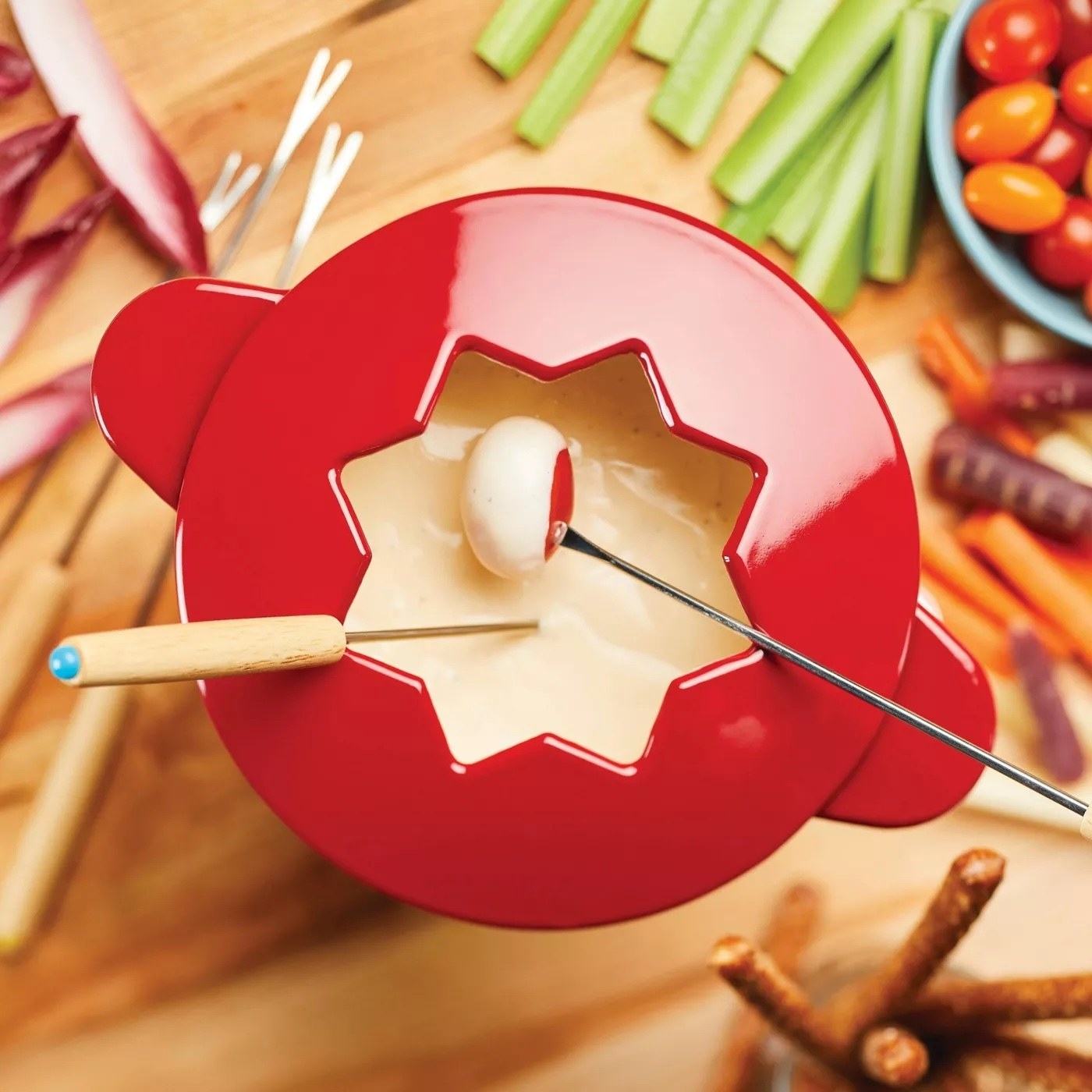 A bright red fondue pot with cheese