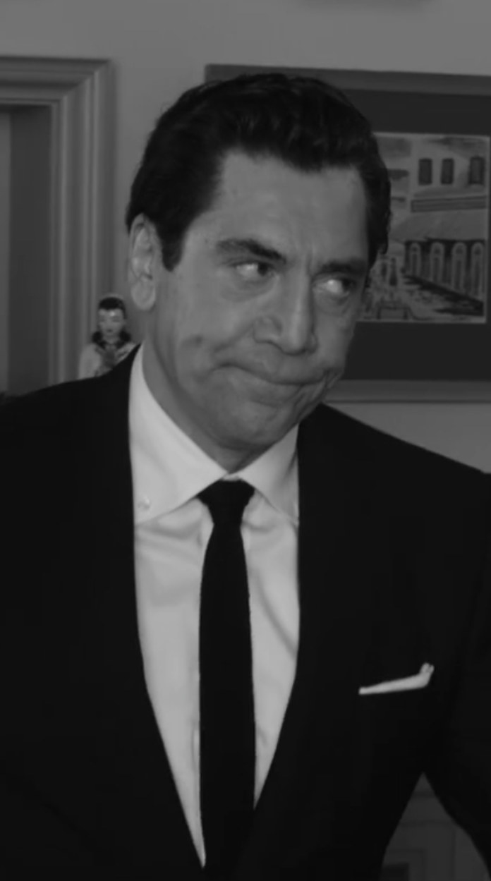 Bardem as Ricky Ricardo, wearing a suit and tie