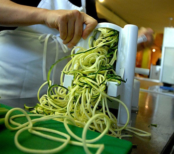 A person spiralizing a vegetable