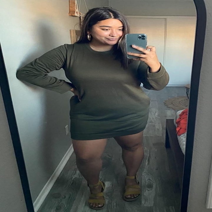 reviewer wearing the dark green sweatshirt dress