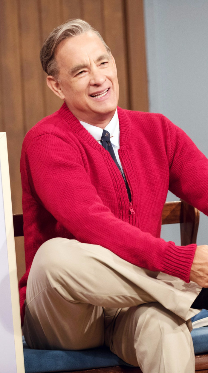 Hanks in a red sweater tying his shoes