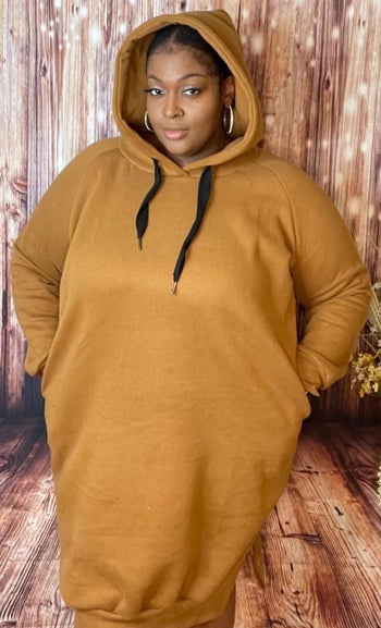 reviewer wearing the gold hoodie dress