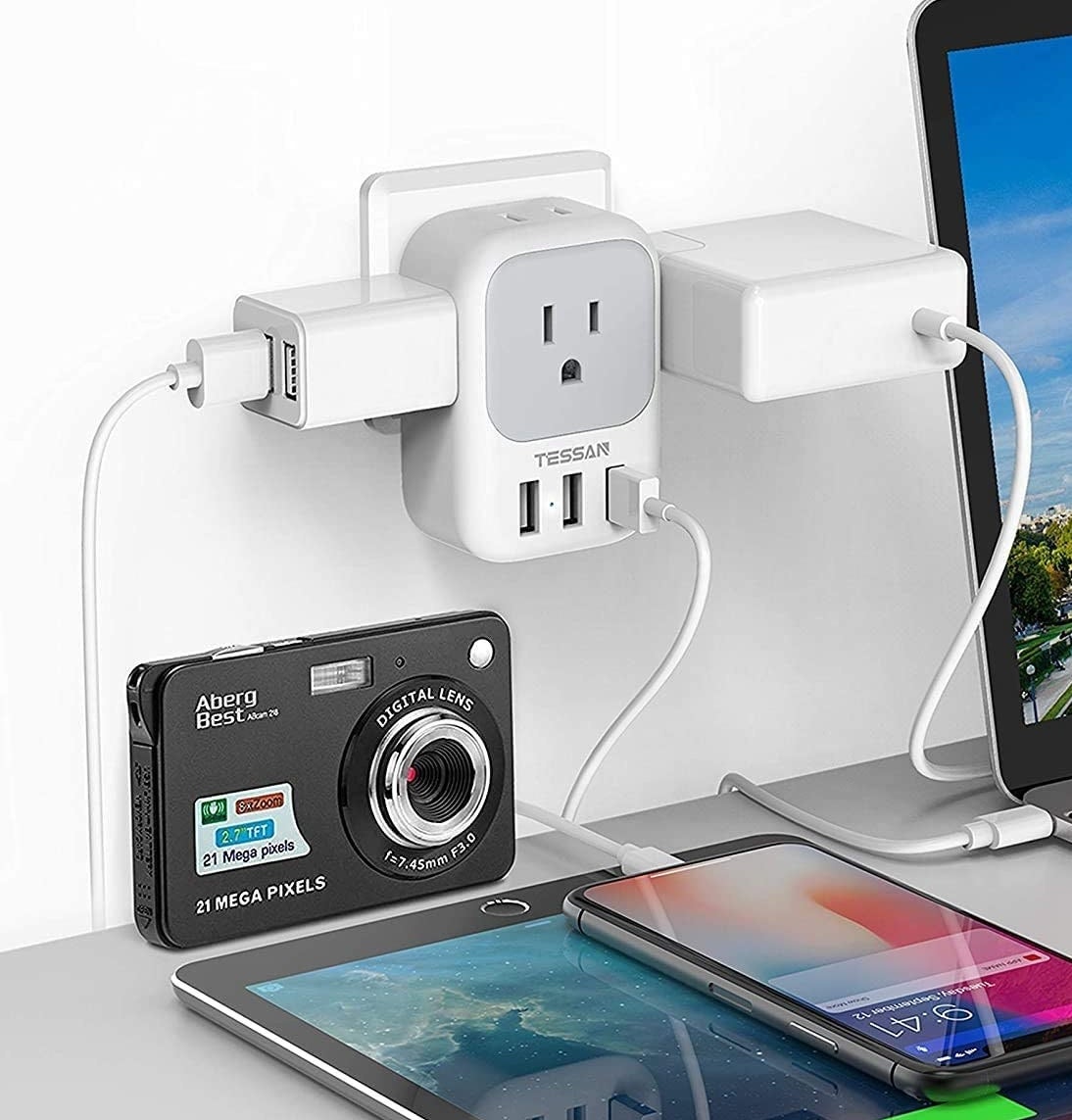 A camera, phone, tablet, and computer plugged into the outlet extender