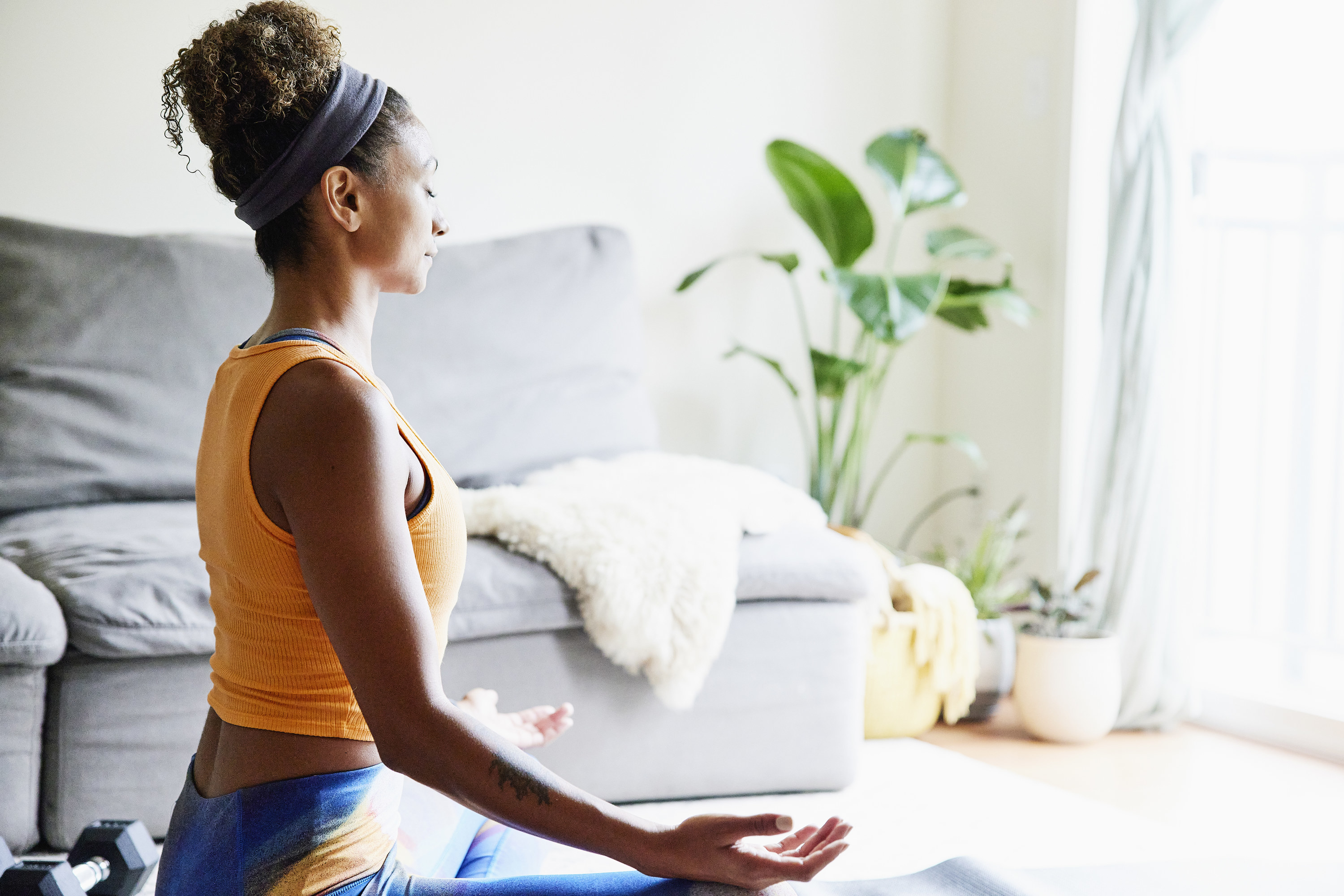 A woman meditating in her living room