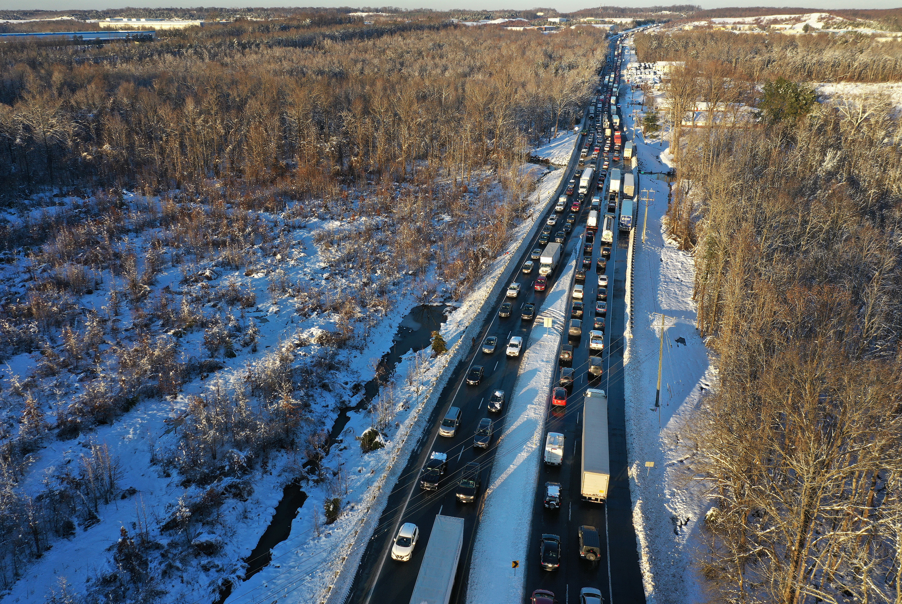 A bunch of cars and trucks stopped on the highway