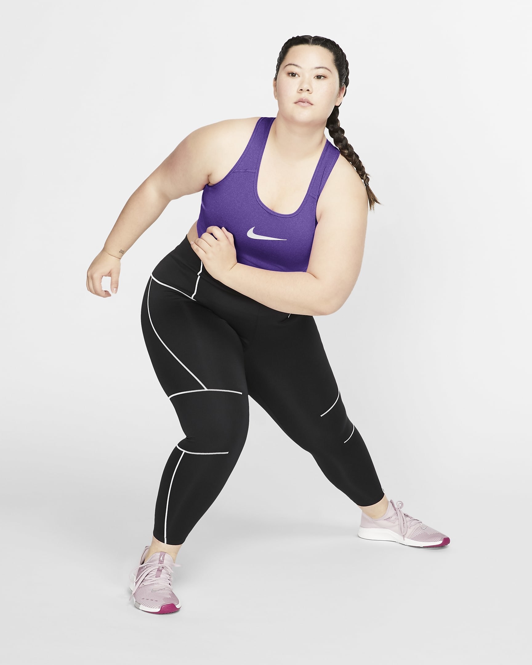 model in dark purple sports bra with Nike logo on the front
