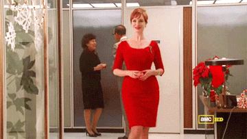 Joan walking around the office flirtatiously