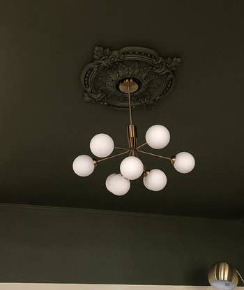reviewer image of medallion installed and painted dark green to match the rest of ceiling