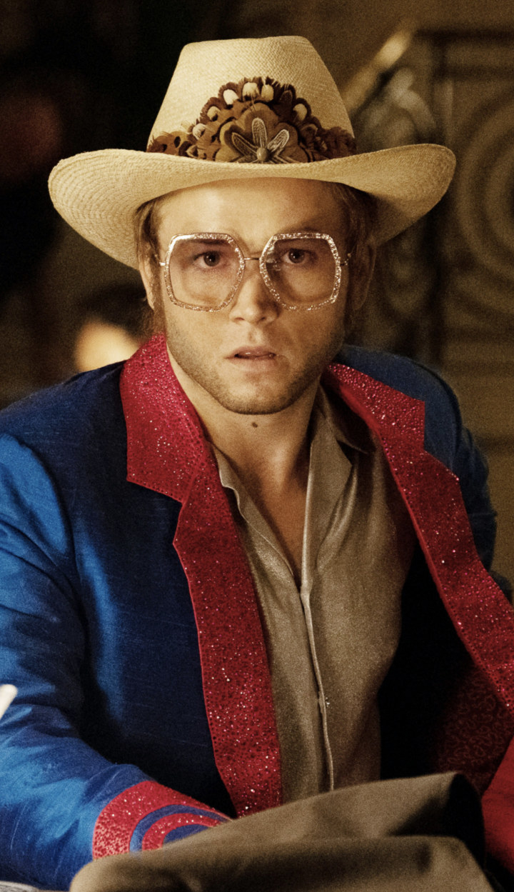 Egerton wearing a cowboy hat and glittered glasses