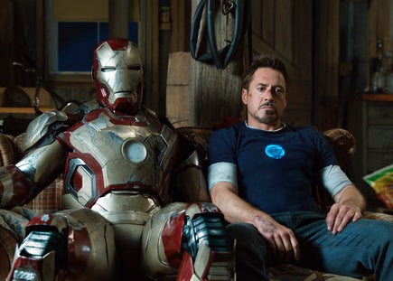Tony Stark sitting beside his suit