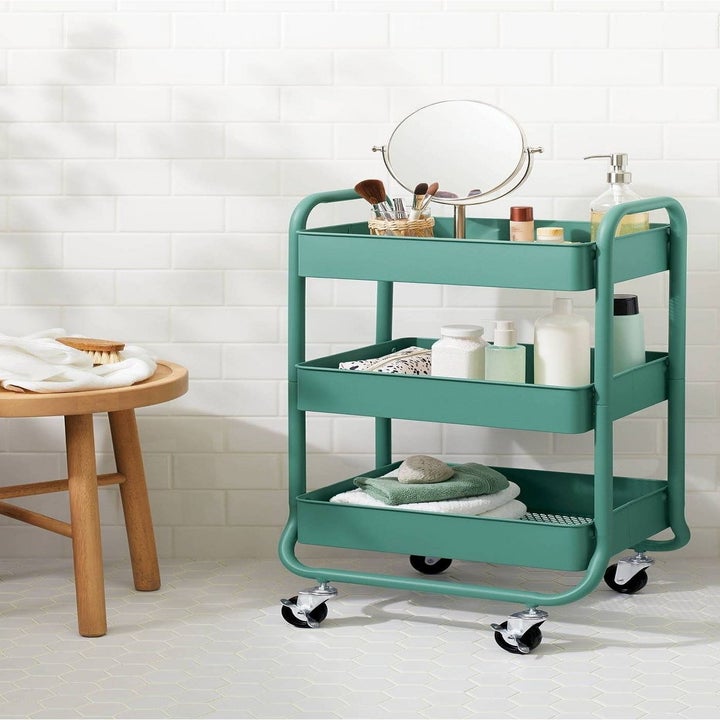 The utility cart in green holding various kitchen items