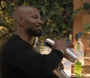 Jamie Foxx smiles and shakes two cocktail mixers in his hand as he sways back and forth in &quot;Off Script a Grey Goose Production&quot;