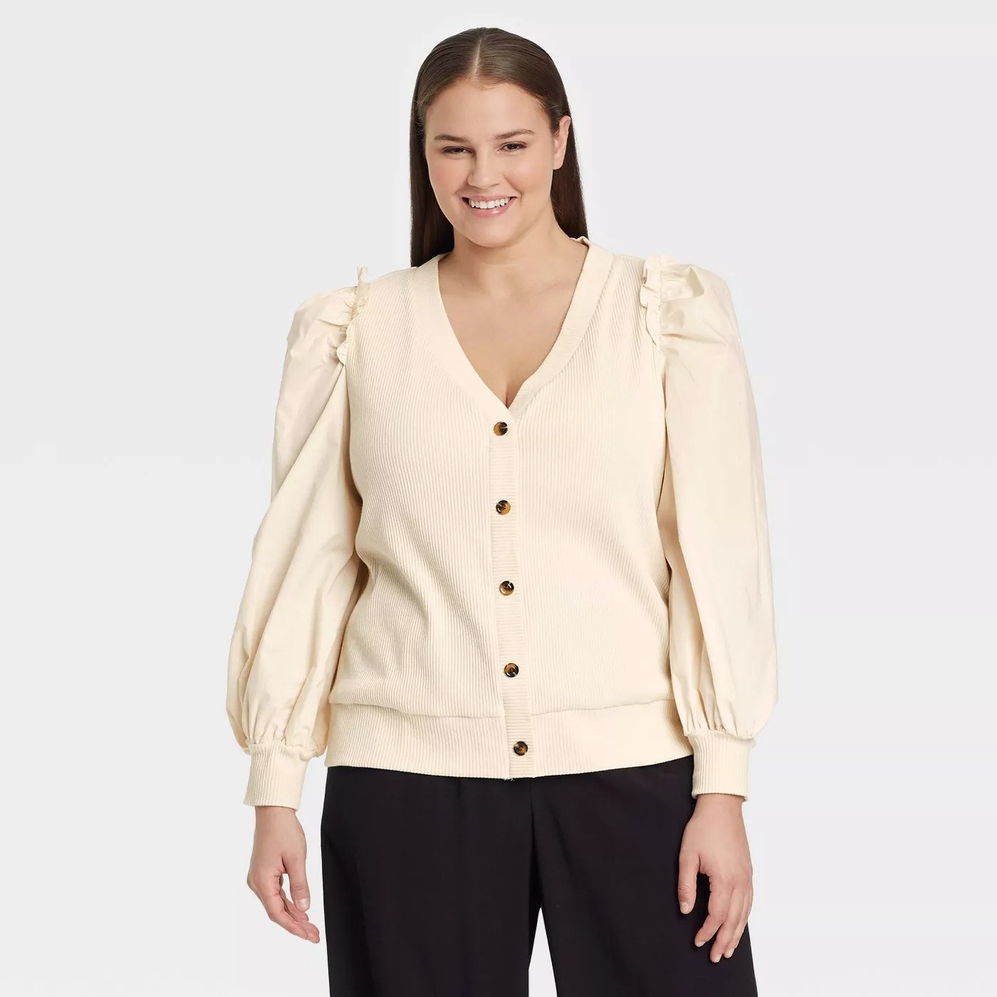 Model wearing cream colored cardigan with brown buttons