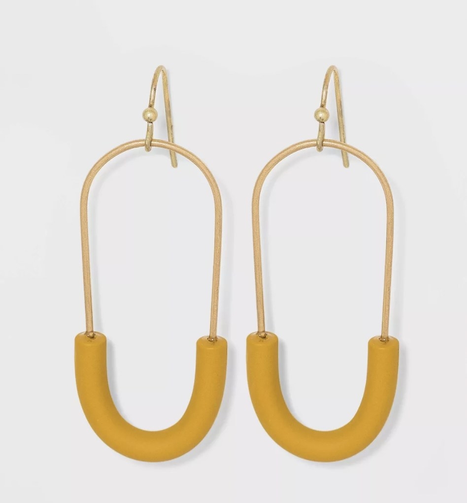 a pair of oval-shaped earrings with mustard tubes at the bottom