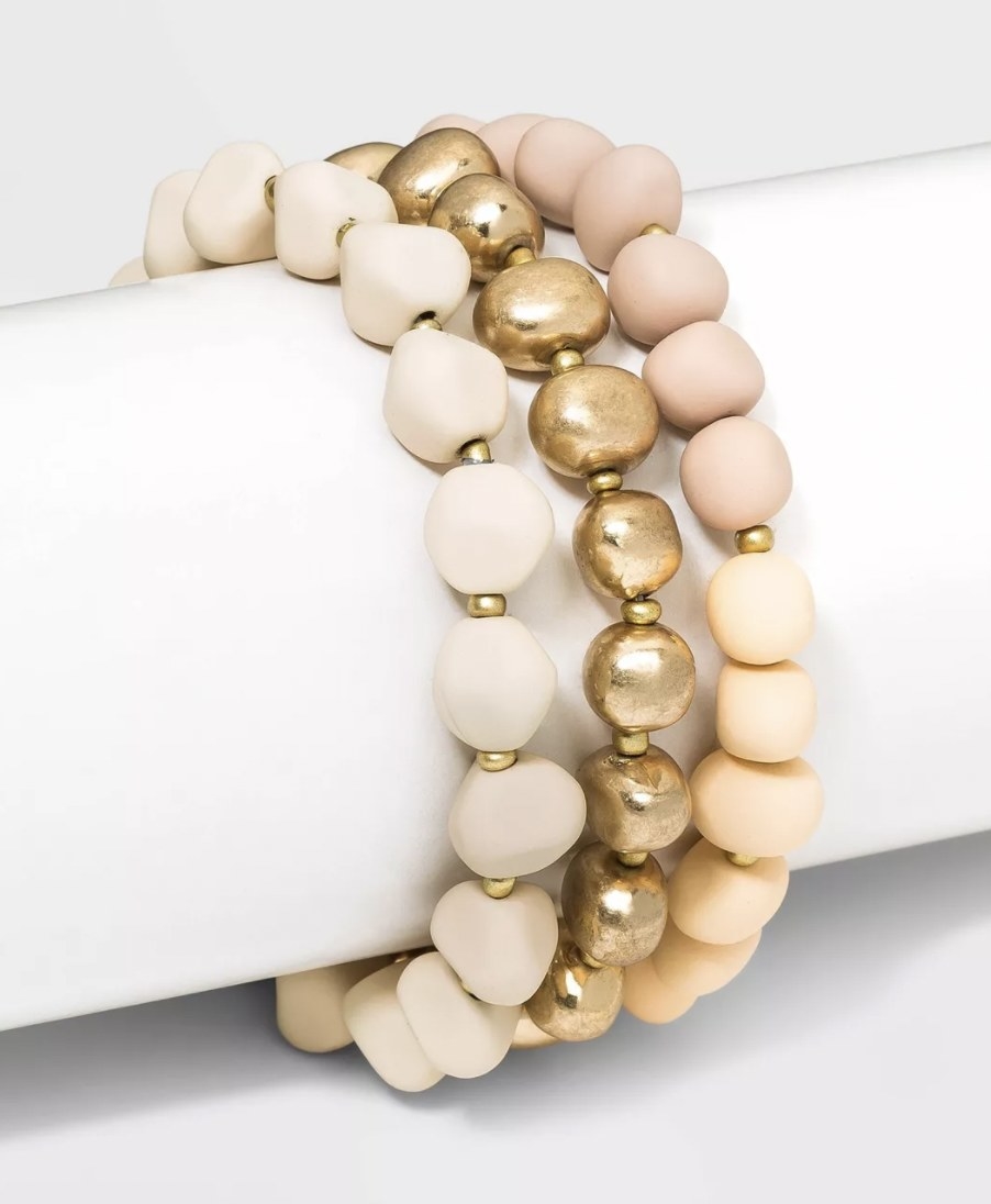 a cream, coral, and gold beaded bracelet set