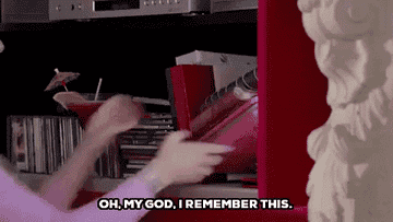 A woman picking up a book and saying