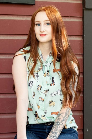 model in mint sleeveless tie neck top printed with different dog breeds